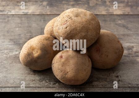 Les pommes de terre crues sur table en bois Banque D'Images