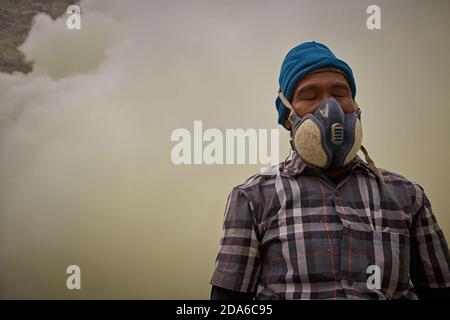 East Java, Indonésie, février 2016. Les mineurs de soufre se reposant de leur dur travail dans le cratère du volcan actif Kawah Ijen. Banque D'Images