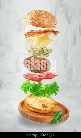 Hamburger volant sur fond de béton gris. Concept de restauration rapide Banque D'Images