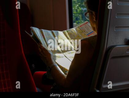 Un passager en train entre Poole et Londres Waterloo lit une grande carte TOURISTIQUE DE A à Z du centre de Londres avec Clerkenwell et Hoxton pendant le trajet de deux heures entre Dorset, via Bournemouth et Southamptoonb, et la capitale du Royaume-Uni. 23 juillet 2014. Photo: Neil Turner Banque D'Images