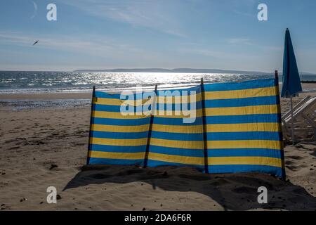 Une pause-vent à rayures bleues et jaunes sur la plage de Boscombe qui est une partie de la célèbre plage de sable de sept kilomètres à Bournemouth et Poole à Dorset. 28 septembre 2015. Photo: Neil Turner Banque D'Images