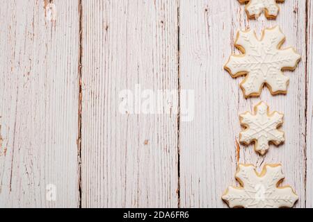 Noël biscuits de sucre décorés formant une bordure sur un bois surface avec espace de copie et espace pour le texte Banque D'Images