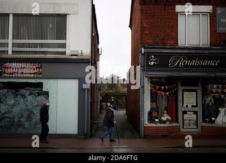 Coalville, Leicestershire, Royaume-Uni. 10 novembre 2020. Les hommes marchent devant une unité de détail vide après que le taux de chômage du Royaume-Uni a augmenté alors que le coronavirus continue de frapper le marché de l'emploi. Credit Darren Staples/Alay Live News. Banque D'Images