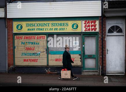 Coalville, Leicestershire, Royaume-Uni. 10 novembre 2020. Une femme passe devant un ancien magasin de rabais après que le taux de chômage au Royaume-Uni ait augmenté alors que le coronavirus continue de frapper le marché de l'emploi. Credit Darren Staples/Alay Live News. Banque D'Images