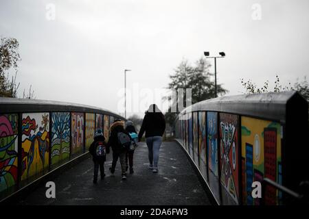 Coalville, Leicestershire, Royaume-Uni. 10 novembre 2020. Une femme marche ses enfants jusqu'à l'école après que le taux de chômage au Royaume-Uni ait augmenté alors que le coronavirus continue de frapper le marché du travail. Credit Darren Staples/Alay Live News. Banque D'Images