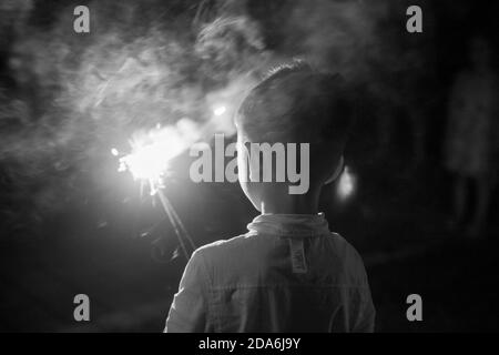 Un garçon tenant un pétards Banque D'Images