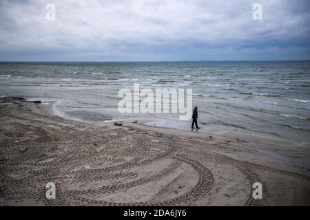 Lubmin, Allemagne. 05ème novembre 2020. Un homme est à la recherche de pierres sur la plage presque déserte, qui a été lavé à nouveau il y a quelques jours, à la mer Baltique. En tant que mesure de protection de la couronne, les touristes doivent quitter le Mecklembourg-Poméranie occidentale d'aujourd'hui au plus tard. Dans toute l'Allemagne, un verrouillage partiel de quatre semaines a commencé le 02.11.2020 pour ralentir la propagation du virus corona. Credit: Jens Büttner/dpa-Zentralbild/ZB/dpa/Alay Live News Banque D'Images