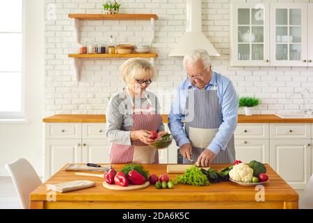 Un mari et une femme de bonne qualité qui font une salade saine ensemble leur cuisine moderne Banque D'Images