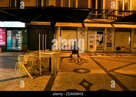 Une femme portant un masque de protection marche dans une rue déserte près du centre de Lisbonne, après avoir imposé le couvre-feu.le Portugal est de nouveau placé en confinement obligatoire selon l'état d'urgence des mesures annoncées par le gouvernement et appliquées dans les 121 conseils à haut risque. Ces mesures ont été imposées dimanche dernier et sont entrées en vigueur à partir du 9 novembre 2020 par le Premier ministre António Costa et son cabinet. Au cours des dernières 24 heures, le Portugal a enregistré 4,096 cas confirmés de COVID-19 et 63 décès selon les données de la Direction générale de la Santé (DG). Banque D'Images