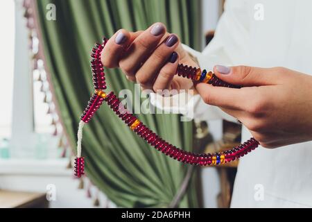 Religieuse asiatique bouddhiste femme priant avec la main tenant des perles rosaires. Disciple bouddhiste femelle méditant, chantant mantra avec la prière de perles rosaires Banque D'Images