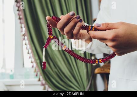 Religieuse asiatique bouddhiste femme priant avec la main tenant des perles rosaires. Disciple bouddhiste femelle méditant, chantant mantra avec la prière de perles rosaires Banque D'Images