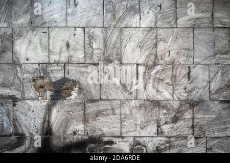 Arrière-plan abstrait grunge. Carreaux sales sur le mur avec des traces floues de suie et de poussière. Mur gris charré après le feu Banque D'Images