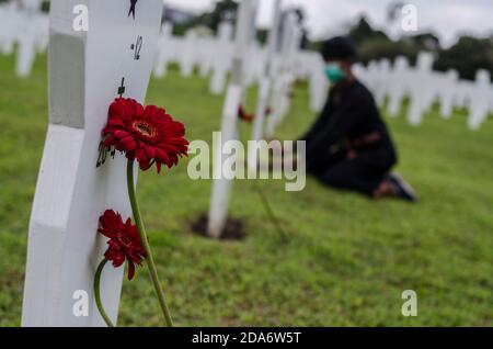 Bandung, Indonésie. 10 novembre 2020. Des fleurs sont déposées sur une pierre tombale lors de la commémoration de la Journée nationale des héros au cimetière des héros de Cikutra à Bandung, Java-Ouest, Indonésie, le 10 novembre 2020. La Journée nationale des héros est célébrée chaque année le 10 novembre en Indonésie. Crédit: Septianjar/Xinhua/Alamy Live News Banque D'Images