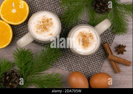 Boisson traditionnelle de vacances aubergine. Boisson sucrée à base d'œufs de poulet crus et de lait. Cocktail de Noël avec noix de muscade râpée et cannelle. Banque D'Images