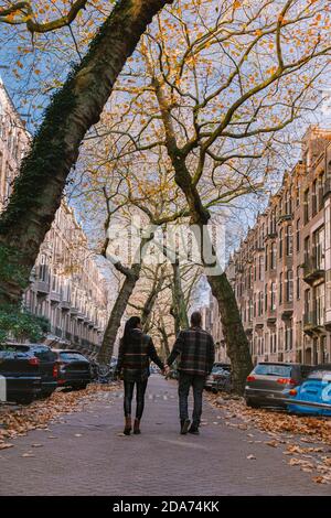 Amsterdam pays-Bas pendant la saison d'automne , couple hommes et femme visitent la ville d'Amsterdam avec des couleurs orange le long du canal en octobre Banque D'Images