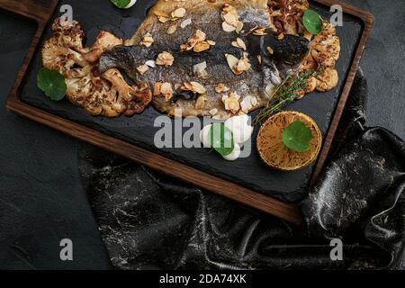 Plats de poisson préparation de la cuisson avec dorado sous forme de support en forme de poisson avec des légumes sains sur fond rustique foncé avec des ingrédients, dessus Banque D'Images