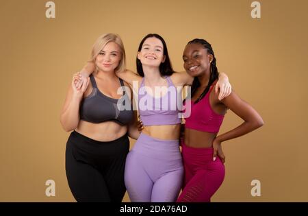 Groupe de femelles positives de corps avec différents types de figure posant Dans Sportswear Banque D'Images