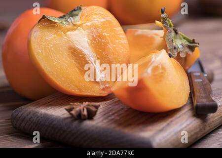 pésimmons frais mûrs et orange jucky coupés en tranches, gros plan. Banque D'Images