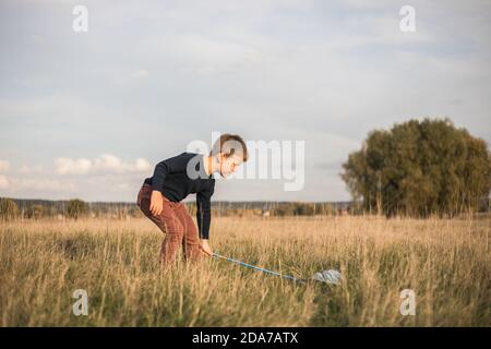 Jeune garçon avec un pré de marche à filet de papillon. Enfant jouant attrapant des insectes. Activités estivales saisonnières pour les enfants en plein air. Apprentissage faune animale monde ho Banque D'Images