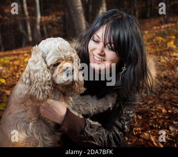 Fille et coq américain épagneul dans la forêt d'automne Banque D'Images