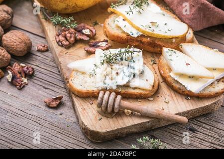 Toast ou canape au fromage de chèvre, au thym, au miel, aux noix. Délicieux hors-d'œuvre, idéal comme apéritif. Banque D'Images