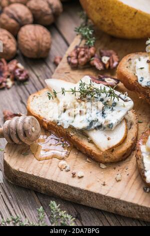 Toast ou canape au fromage de chèvre, au thym, au miel, aux noix. Délicieux hors-d'œuvre, idéal comme apéritif. Banque D'Images