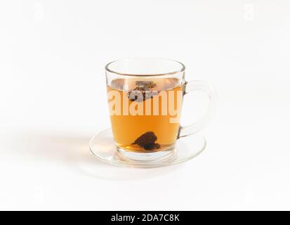 Thé aux champignons chaga dans une tasse de verre isolée sur fond blanc. Boisson biologique saine. Vue latérale. Banque D'Images