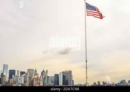 Le drapeau américain agite fièrement. Manhattan, New York, Cityscape in Background Banque D'Images