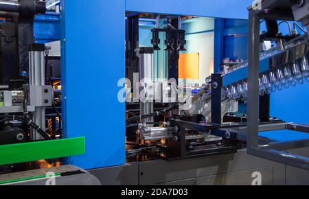 Processus d'embouteillage de plastique PET sur le processus de préchauffage de la machine de soufflage de bouteilles. Chaîne de production industrielle Banque D'Images