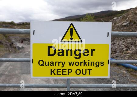 Panneau « danger Quarry rouages Keep Out » sur une porte en métal galvanisé à l'entrée d'une carrière, en Écosse. Banque D'Images