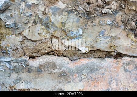 Ancienne texture d'arrière-plan de mur peint abîmé. Mur en plâtre léger et pelé avec des flocons de peinture qui tombent Banque D'Images