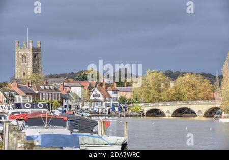 Un ciel sombre au-dessus des bâtiments éclairés par le soleil à Henley-on-Thames sur une chaude journée d'automne Banque D'Images