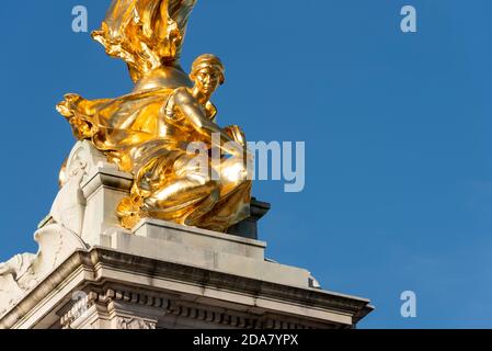 Un détail du Victoria Memorial à l'extérieur de Buckingham Palace dans le Mall, Londres, Royaume-Uni. C'est la constance, en dessous de la victoire aigée, en or doré, ciel bleu Banque D'Images