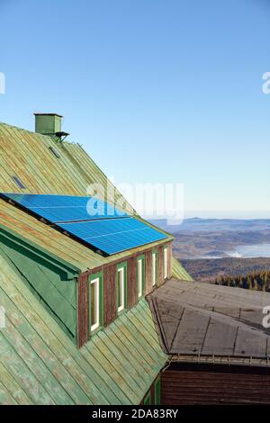 Panneaux solaires sur un toit d'un ancien abri de montagne. Banque D'Images