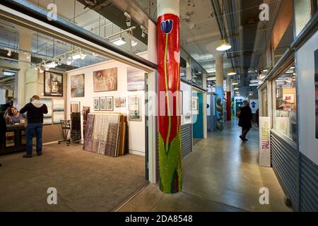 Les clients magasinent dans certaines galeries d'art du centre artistique Torpedo Factory dans la vieille ville d'Alexandria, en Virginie. Une colonne est peinte avec un Banque D'Images