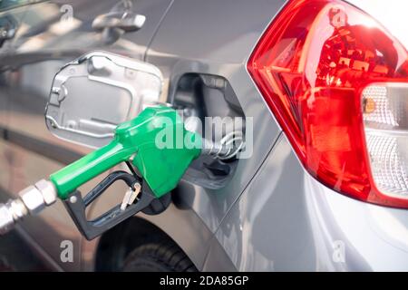 Homme à une station-service de pompe à essence qui insère le gicleur dans réservoir de carburant d'une voiture et démarrage du pompage de carburant dans la pompe petro diesel à coupure automatique Banque D'Images