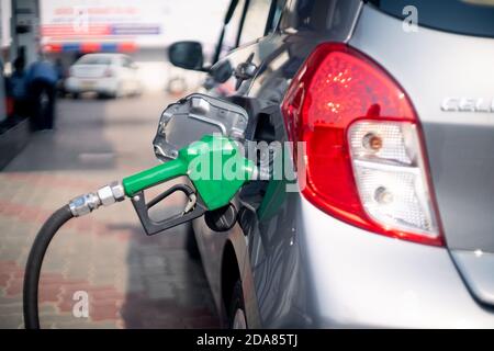 Homme à une station-service de pompe à essence qui insère le gicleur dans réservoir de carburant d'une voiture et démarrage du pompage de carburant dans la pompe petro diesel à coupure automatique Banque D'Images