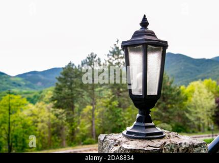 Vieille lampe de rue, avec montagne et arbres dans le bacille Banque D'Images