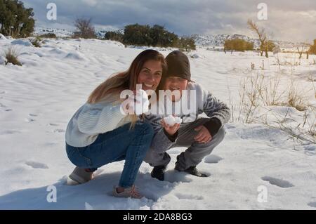 bonne famille, mère et fils jouant dans la neige par beau temps Banque D'Images