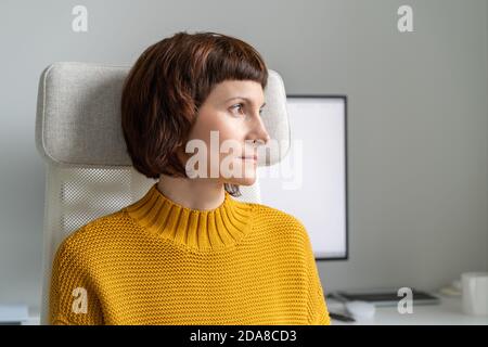 Femme regardant la fenêtre et prenant une pause de travail sur l'ordinateur. Banque D'Images
