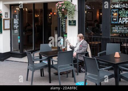 Homme lisant un livre et appréciant une pinte à l'extérieur d'un Pub, Londres, Royaume-Uni Banque D'Images