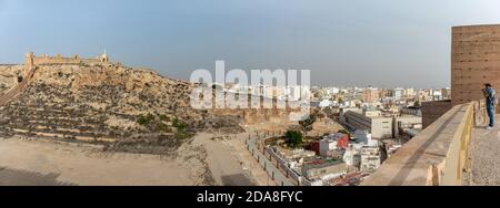 Alcazaba fortification islamique construite sur une colline, ville d'Almería à l'arrière-plan, mâle touriste prenant des photos de vacances. Vue panoramique Almería Banque D'Images