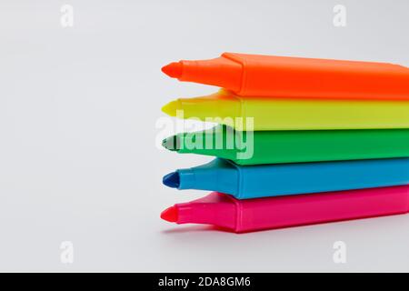Vue latérale des stylos surligneurs empilés sans bouchon sur fond blanc uniforme, à utiliser pour une présentation ou une réunion d'affaires Banque D'Images
