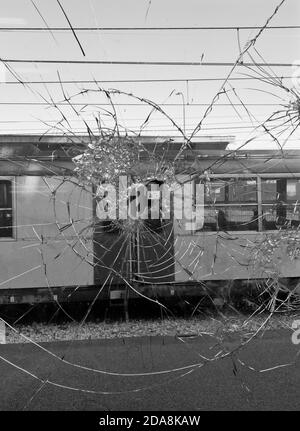 Regarder un train à travers du verre brisé dans une fenêtre Dans cette photo en noir et blanc prise dans le sud de l'Italie Banque D'Images