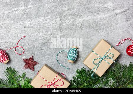 Composition de Noël. Cadeaux de Noël, ornements, arbre à feuilles persistantes et rubans sur fond de pierre grise. Flat lay, vue de dessus, espace de copie. Banque D'Images