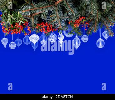 Fond de Noël bleu avec bordure décorée de boules de Noël blanches de formes différentes et avec des branches d'épinette et des tangerines Banque D'Images