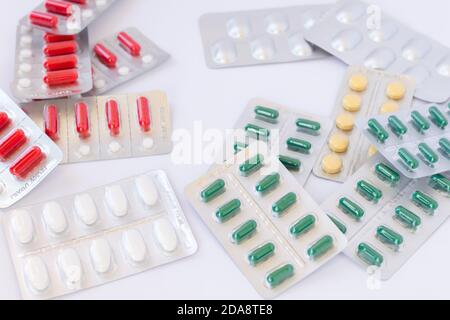 Beaucoup de pilules de médicaments avec des couleurs, des tailles et des formes diferentes dans les plaquettes thermoformées boîtes désordonnées. Banque D'Images