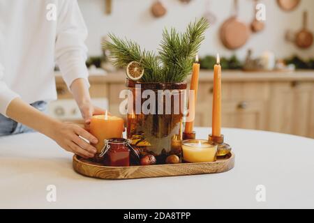 Une femme décorera une table de Noël avec des bougies. Gros plan. Banque D'Images