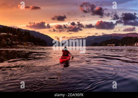 Aventure fille pagayant sur un kayak rouge vif Banque D'Images