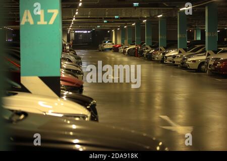 Parking intérieur dans le centre commercial, de nombreuses voitures de différentes marques et un espace libre pour le texte. Place de stationnement numéro A17. Banque D'Images